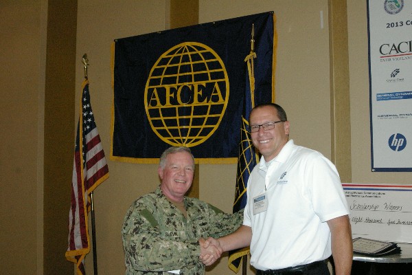 In April, Capt. Gerry Slevin, USN, chapter president, congratulates Chad Fisher, former publicity chair, for his dedication to the publicity role within the chapter.